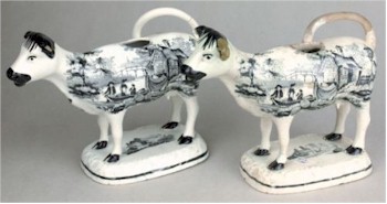 A pair of Glamorgan pottery cow creamers with transfer printed decoration, circa 1815-35.