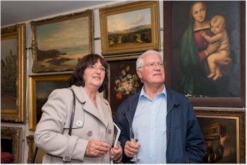 Barbara and Chris Weaving from Paignton looking at paintings at the preview evening held in Exeter, Devon.