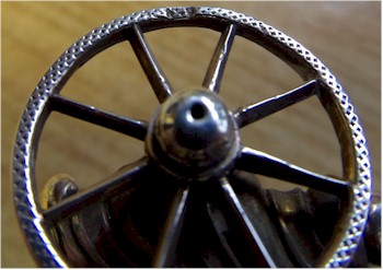 One of the wheels on the silver novelty toothpick holder.