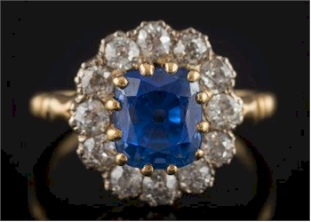 A Cushion Shaped Sapphire and Diamond Cluster Ring (FS32/259) sold for £6,300 in the jewellery auction of the October 2016 Fine Sale.